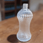 Frasco de vidro 100 ml cinturinha com rosca R18/415. Design vintage e sofisticado, ideal para perfumes, aromatizadores e lembranças personalizadas. Veja mais!